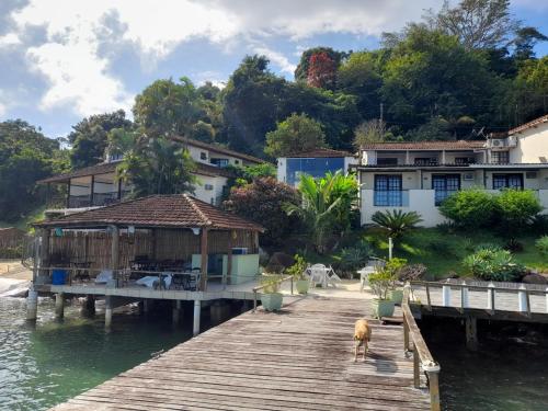 a house on a dock next to a body of water at Suites Ponta Leste in Angra dos Reis