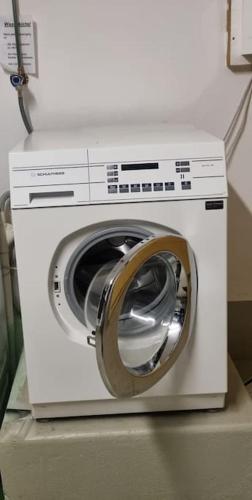a washing machine sitting on top of a refrigerator at House of Thun Full Apartment in Thun