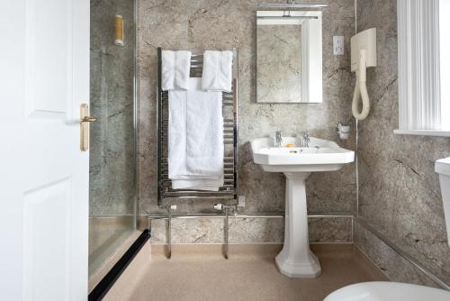 W łazience znajduje się umywalka i lustro. w obiekcie Imperial Hotel w mieście Great Yarmouth