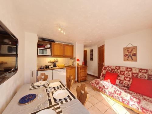 Il comprend une cuisine et un salon avec une table. dans l'établissement Les Chalets d Or - B03 - Appt terrasse 4 pers, à Les Deux Alpes