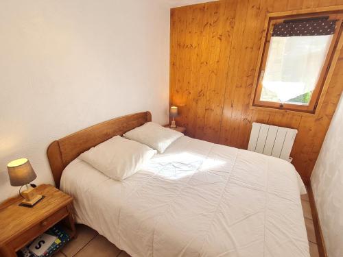 Un pequeño dormitorio con una cama blanca y una ventana en Les Chalets d Or - B03 - Appt terrasse 4 pers, en Les Deux Alpes