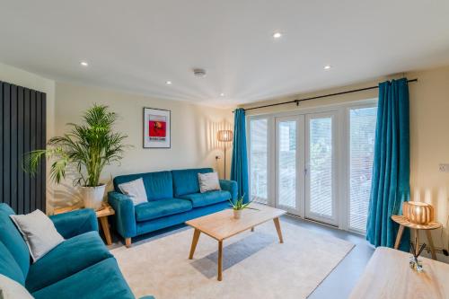 a living room with a blue couch and a table at The Weir House in Symonds Yat