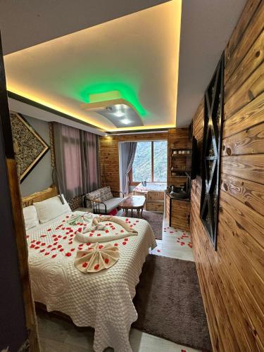 a hotel room with a bed and a living room at Peruma otel bungalov in Çamlıhemşin