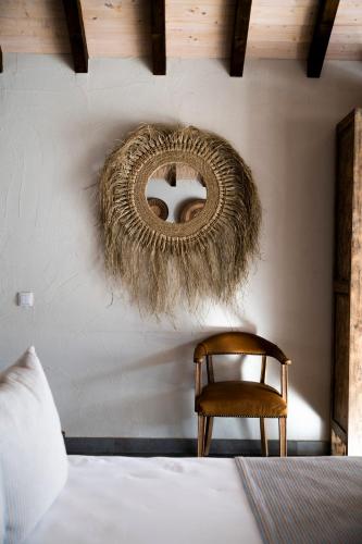 a bedroom with a bed and a rattan mirror on the wall at Sublime Comporta Country Retreat & SPA in Comporta