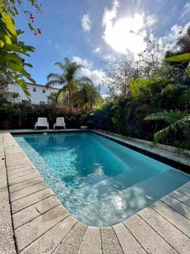a swimming pool with two chairs in a yard at Delight and cozy Apt close to Las Olas & the beach in Fort Lauderdale