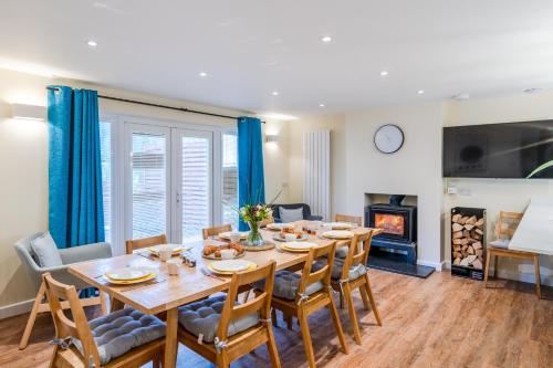 a dining room with a table and chairs and a fireplace at The Weir House in Symonds Yat