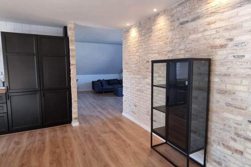 a living room with a brick wall and a glass cabinet at Newly renovated, great location in Aalborg
