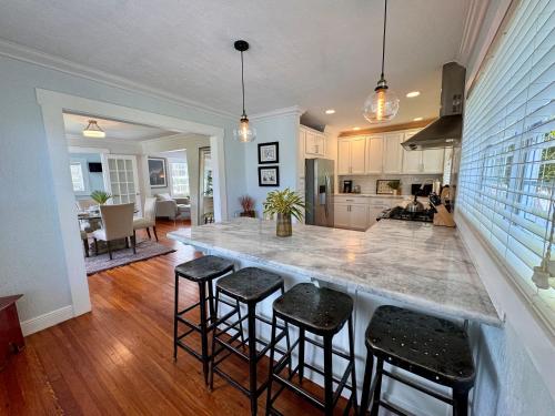 a kitchen with a large island with bar stools at Flamingo Park Bungalow! WALK TO DOWNTOWN WPB!! in West Palm Beach