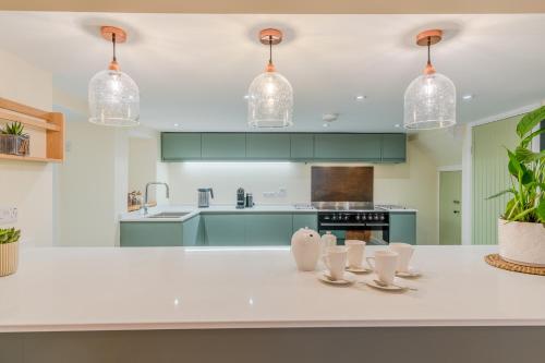 a kitchen with green cabinets and a white counter top at The Weir House in Symonds Yat