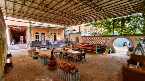 an outdoor patio with tables and chairs in a building at New Dap Hostel (in Grape Town) in Turfan