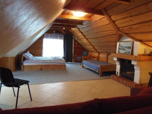 Großes Zimmer mit einem Bett und einem Kamin in einer Hütte in der Unterkunft Dīva in Pāvilosta