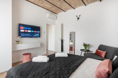 um quarto com uma cama e uma televisão na parede em W STUDIO TERMINI em Roma