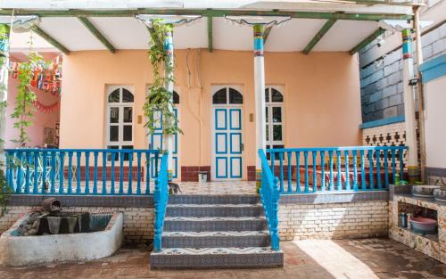 a house with blue gates and stairs in front of it at New Dap Hostel (in Grape Town) in Turfan