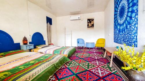 a bedroom with two beds and a table and chairs at New Dap Hostel (in Grape Town) in Turfan