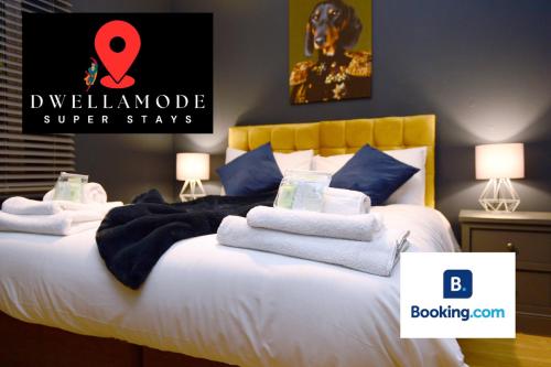 a bedroom with a bed with white sheets and blue pillows at 5 Bedroom House - DISC0UNTS - Parking, Contractors, Group, Family in Canterbury
