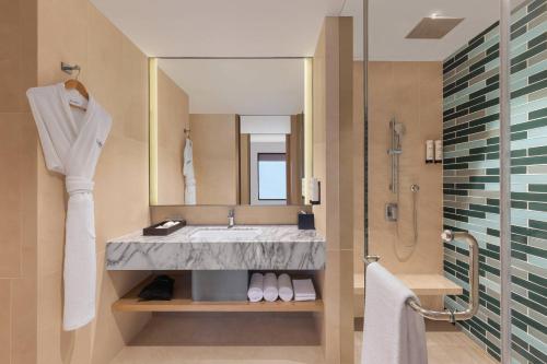 a bathroom with a sink and a large mirror at Fairfield by Marriott Dehradun in Dehradun