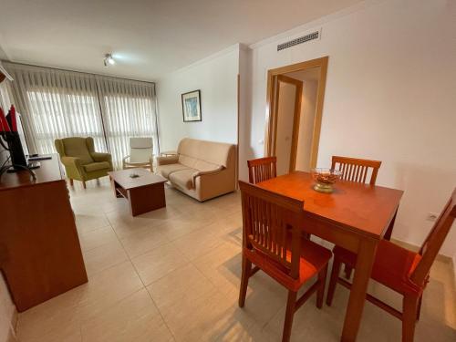 a living room with a dining room table and a couch at Oropesa Ciudad de Vacaciones 3000 in Oropesa del Mar