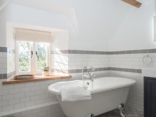 uma casa de banho branca com uma banheira e uma janela em Cilbronnau Lodge Cardigan em Llechryd