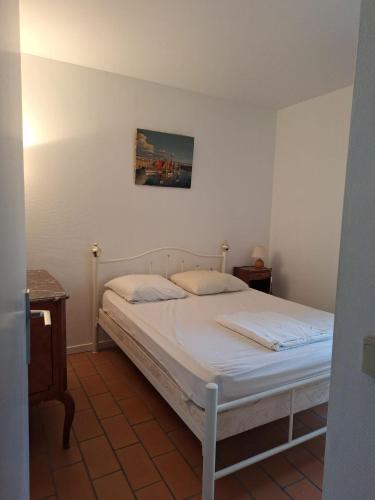 une chambre avec un lit et un tableau au mur dans l'établissement Vue Exceptionnelle CASSIS, à Cassis