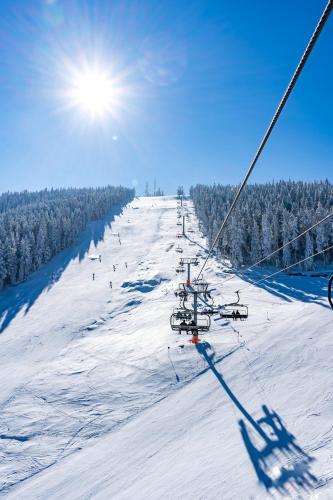 a ski lift going down a snow covered slope at SkyLine Lux 2 Apartman Zlatibor in Zlatibor