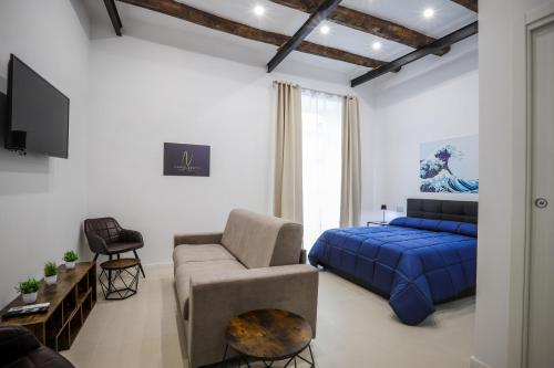 a living room with a blue bed and a couch at Napolidays Rua Catalana Apartment in Naples