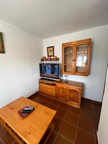 salon z telewizorem i stołem w obiekcie Casa La Ranera de Santillana w mieście Santillana del Mar