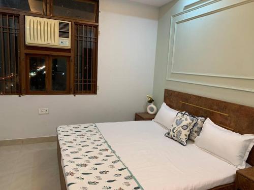 a bedroom with a white bed with a window at Neewara Residency Apartment in Jaipur