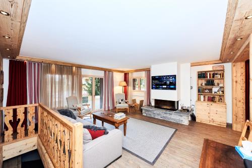 a living room with a couch and a fireplace at Route de Tsarbouye 17, 4BR, Les Dauphinelles in Crans-Montana