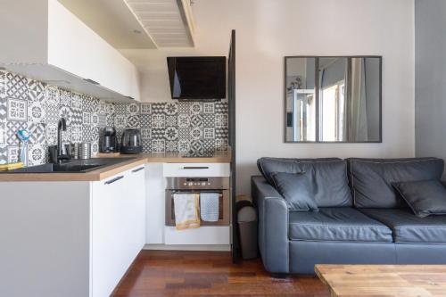 un salon avec un canapé et une cuisine dans l'établissement charmant Studio mezzanine, à Biscarrosse