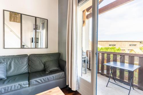 d'un salon avec un canapé et un balcon. dans l'établissement charmant Studio mezzanine, à Biscarrosse