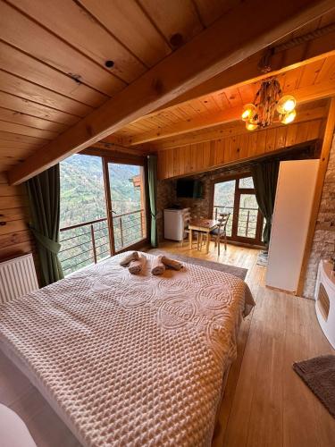 a large bed in a room with a large window at Peruma otel bungalov in Çamlıhemşin