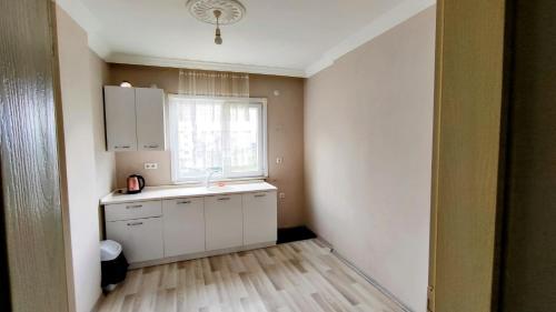 una cocina con armarios blancos y una ventana en elva suites ardeşen, en Ardeşen