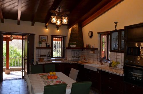 une grande cuisine avec une table et un évier dans l'établissement Sombra del Laurel, à Valleseco