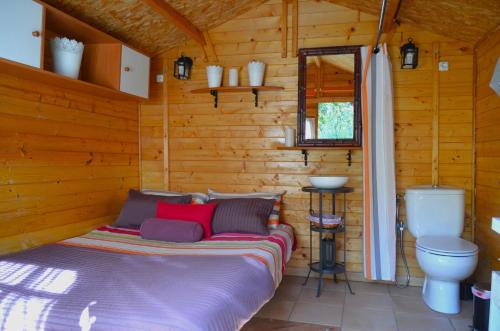 - une chambre avec un lit dans une cabane en rondins dans l'établissement Sombra del Laurel, à Valleseco