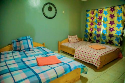 a bedroom with two beds and a mirror on the wall at Africa Rising Cycling Center in Ruhengeri