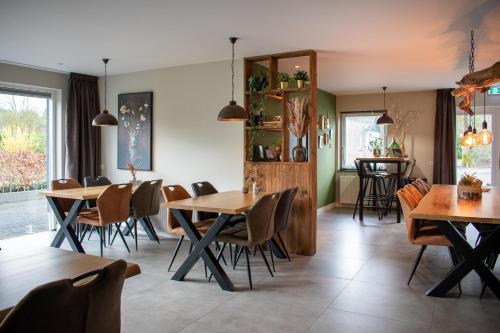 uma sala de jantar com mesas e cadeiras de madeira em Hotel B&B Buiten Loon em Loon op Zand