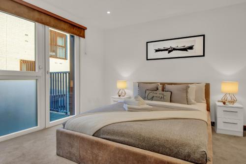 a bedroom with a large bed and a large window at Modern Apartments close to Colombia Road Flower Market in London