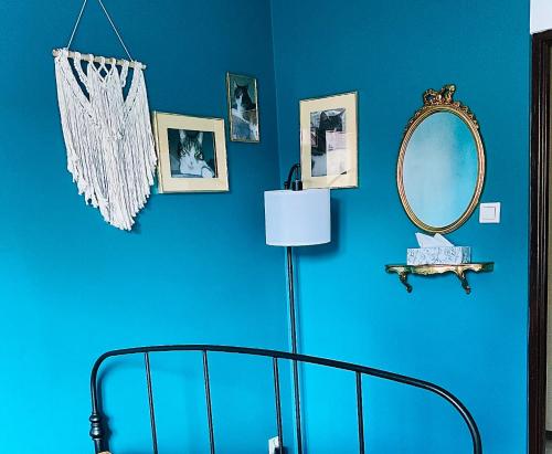 - une chambre bleue avec un lit et un miroir dans l'établissement Apartament na Starym Mieście, à Bolesławiec