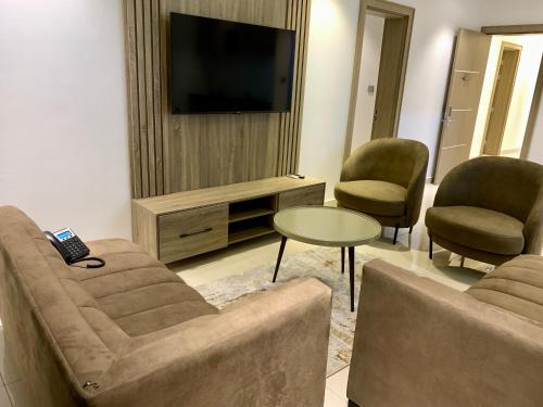 a living room with two chairs and a television at Polo Grand Hotel in Maiduguri