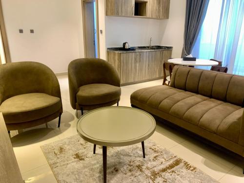 ein Wohnzimmer mit einem Sofa, 2 Stühlen und einem Tisch in der Unterkunft Polo Grand Hotel in Maiduguri