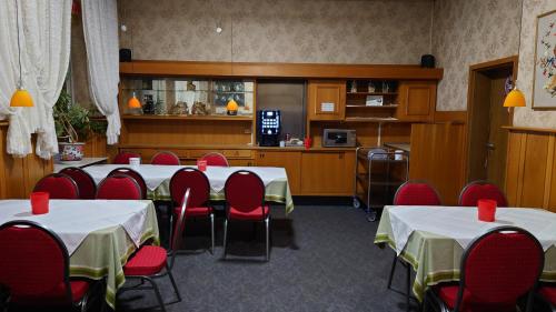 Hotel Westfälischer Hof في هاتنغن: غرفة بها طاولات وكراسي حمراء ومطبخ