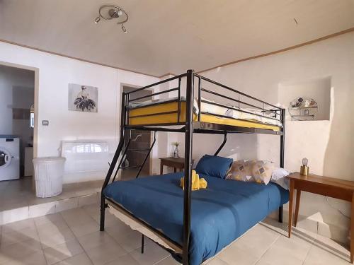a bedroom with a bunk bed with blue sheets at Le Temps Suspendu - Maison atypique avec terrasse in Fitou