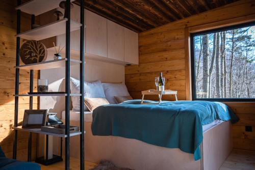 a bedroom with a bed in a wooden cabin at Chatka Nomád na Obrovisku in Muráň