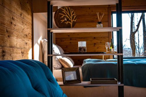 a bedroom with a blue bed and a wooden wall at Chatka Nomád na Obrovisku in Muráň