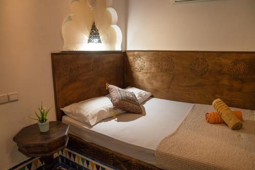 a bedroom with a bed with a wooden head board at Dar Sunrise Fes in Fès