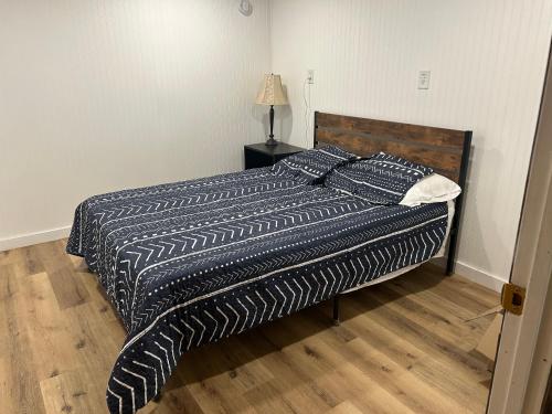 ein Bett mit einer schwarzen und weißen Bettdecke in einem Schlafzimmer in der Unterkunft Border Queen Bunkhouse in Caldwell
