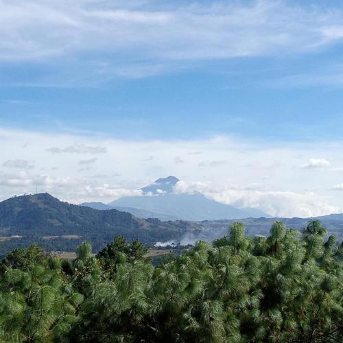 a mountain in the distance with trees in the foreground at Finca Chuchiyá cabañas Tecpan in Tecpán Guatemala