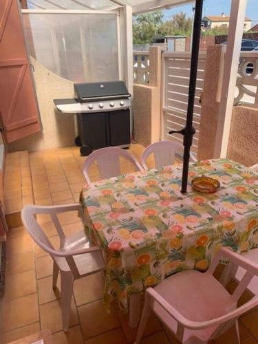 une cuisine avec une table, des chaises et une cuisinière dans l'établissement House T3 for 6 people, à Frontignan
