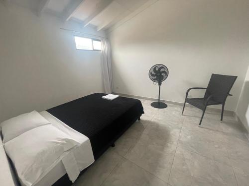 1 dormitorio con 1 cama, 1 silla y ventilador en Apartamento cómodo , céntrico y bien ubicado Apto 402, en Medellín