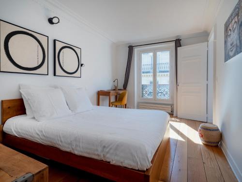 une chambre avec un lit blanc et une fenêtre dans l'établissement Paris Center - Haussmann Elegant Residence, à Paris